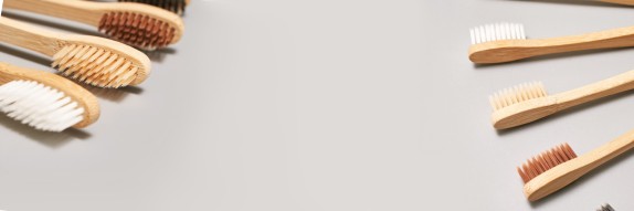 Zahnbürsten liegen aufgefächert auf beigem Grund