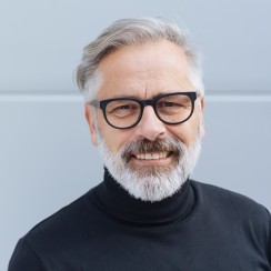 Älterer Mann mit Brille lächelt